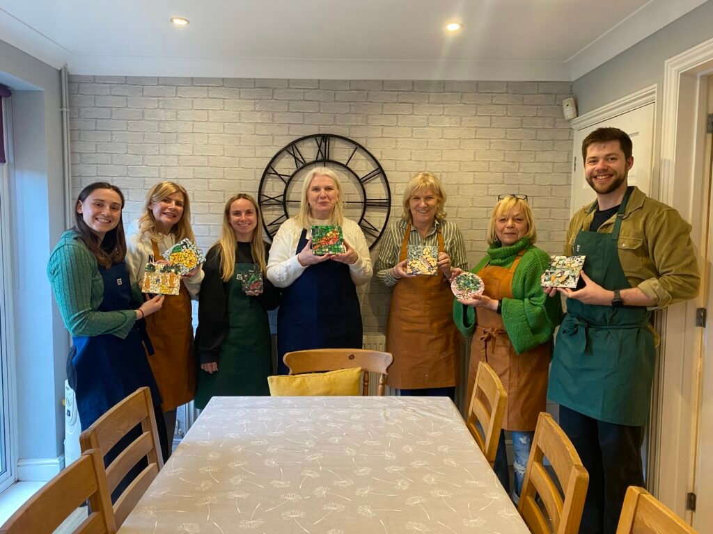 Small group showing their mosaic creations at the end of their team building workshop